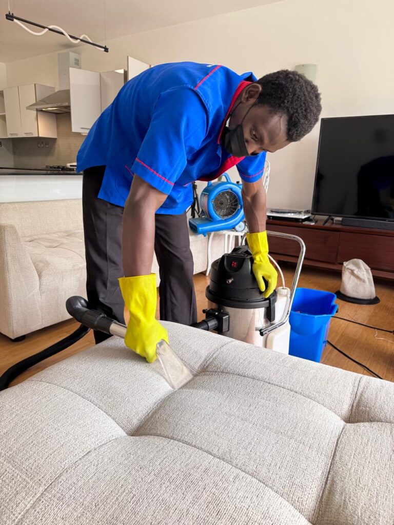 Professional sofa cleaning service technician cleaning a fabric sofa.